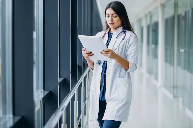 attractive-female-doctor-standing-with-documents-hospital_1303-20690.webp