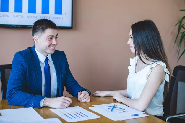 businesswoman-man-sitting-table_23-2147626554.webp