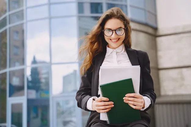 businesswoman-standing-outdoors-city-office-building_1157-36114.webp