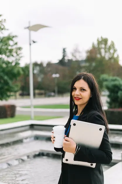 businesswoman-with-disposal-cup-laptop-looking-camera_23-2147970966.webp