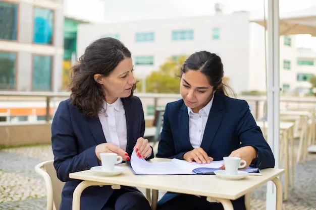 businesswomen-working-with-papers-outdoor-cafe_74855-4975.webp