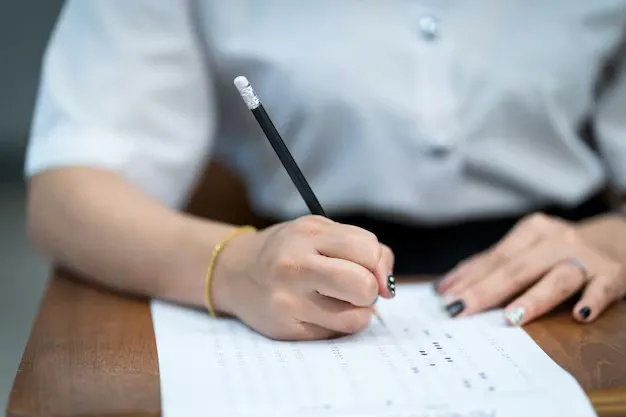 close-up-young-university-students-concentrate-doing-examination-classroom-girl-student-writes-examinations-answer-paper-classroom_201468-213.webp