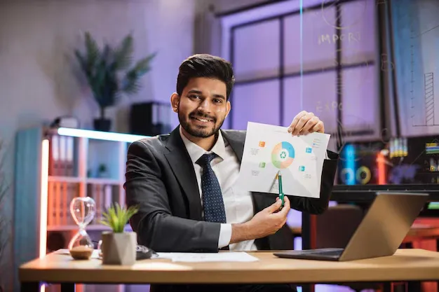 confident-arab-financial-expert-office-worker-suit-working-laptop-showing-paper-report_769609-334.webp