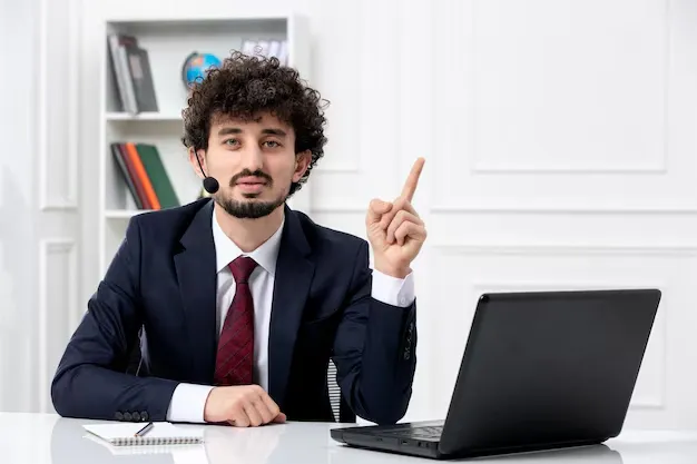 customer-service-handsome-young-guy-office-suit-with-laptop-headset-pointing-up_140725-164875.webp