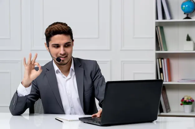 customer-service-pretty-gentleman-with-computer-grey-office-suit-showing-ok-sign_140725-166094.webp