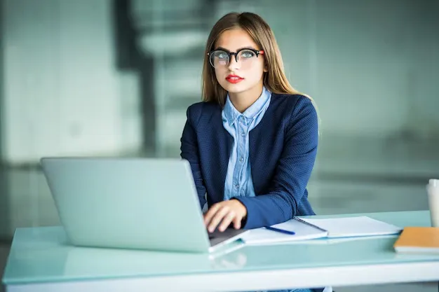 elegant-cheerful-businesswoman-cheerful-young-beautiful-woman-glasses-looking-with-smile-while-sitting-her-working-place_231208-5888.webp