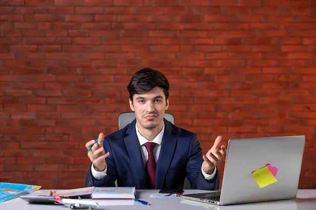 front-view-male-engineer-sitting-his-working-place-with-laptop-suit-work-plan-contractor-occupation-builder-job-corporate-project_461922-16159.webp