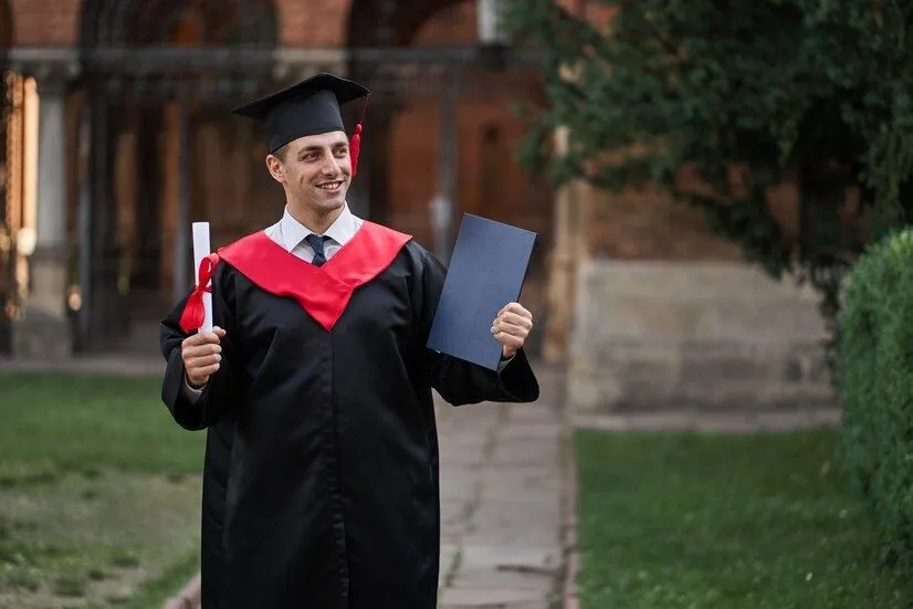 graduate_guy_graduation_gown_with_diploma_his_hands_campus_496169_1280_2446779793.webp