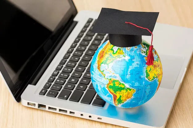 high-angle-globe-with-academic-cap-laptop_23-2148756555.webp