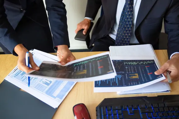 investor-trader-discussing-statistic-data-holding-papers-with-financial-charts-pen-cropped-shot-broker-job-trading-concept_74855-14252.webp