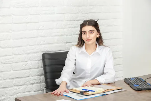 photo-young-businesswoman-sitting-desk-looking-camera-high-quality-photo_144627-75121.webp