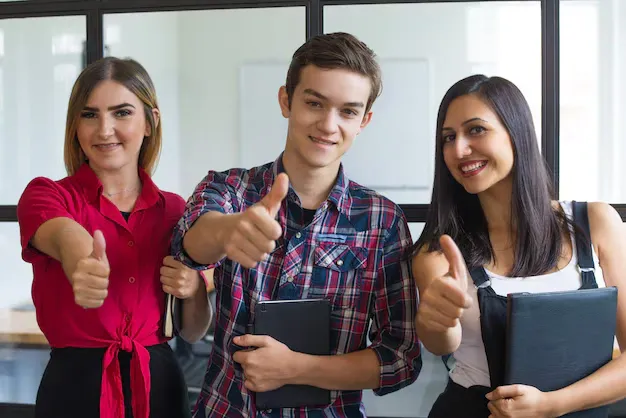 portrait-successful-young-students-showing-thumbs-up_1262-18009.webp