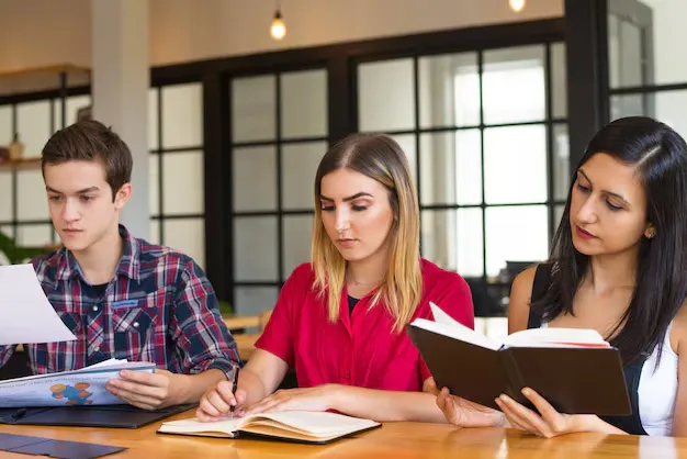 portrait-three-serious-students-studying-library_1262-18011.webp