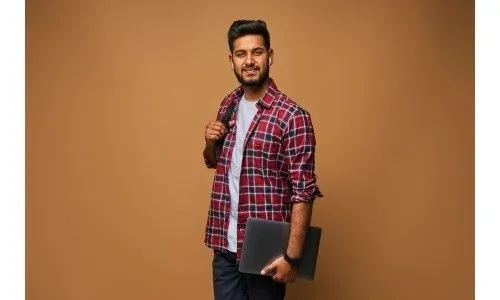 smiling_indian_man_casual_close_with_laptop_backpack_pastel_wall_1_6a07a5862f.webp