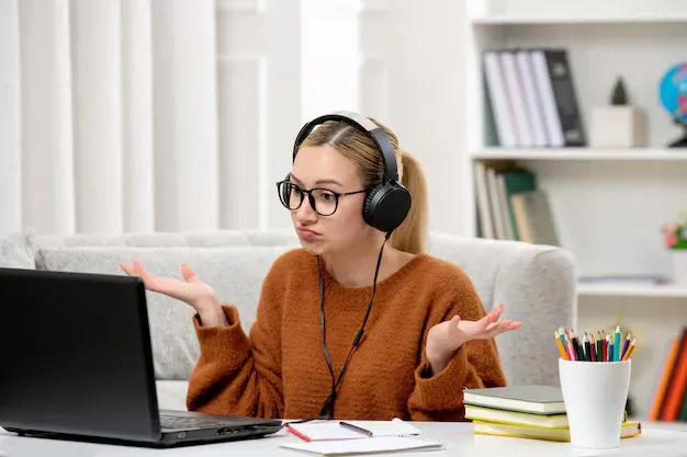 student-online-young-cute-girl-glasses-orange-sweater-studying-computer-waving-hands_140725-163231.webp